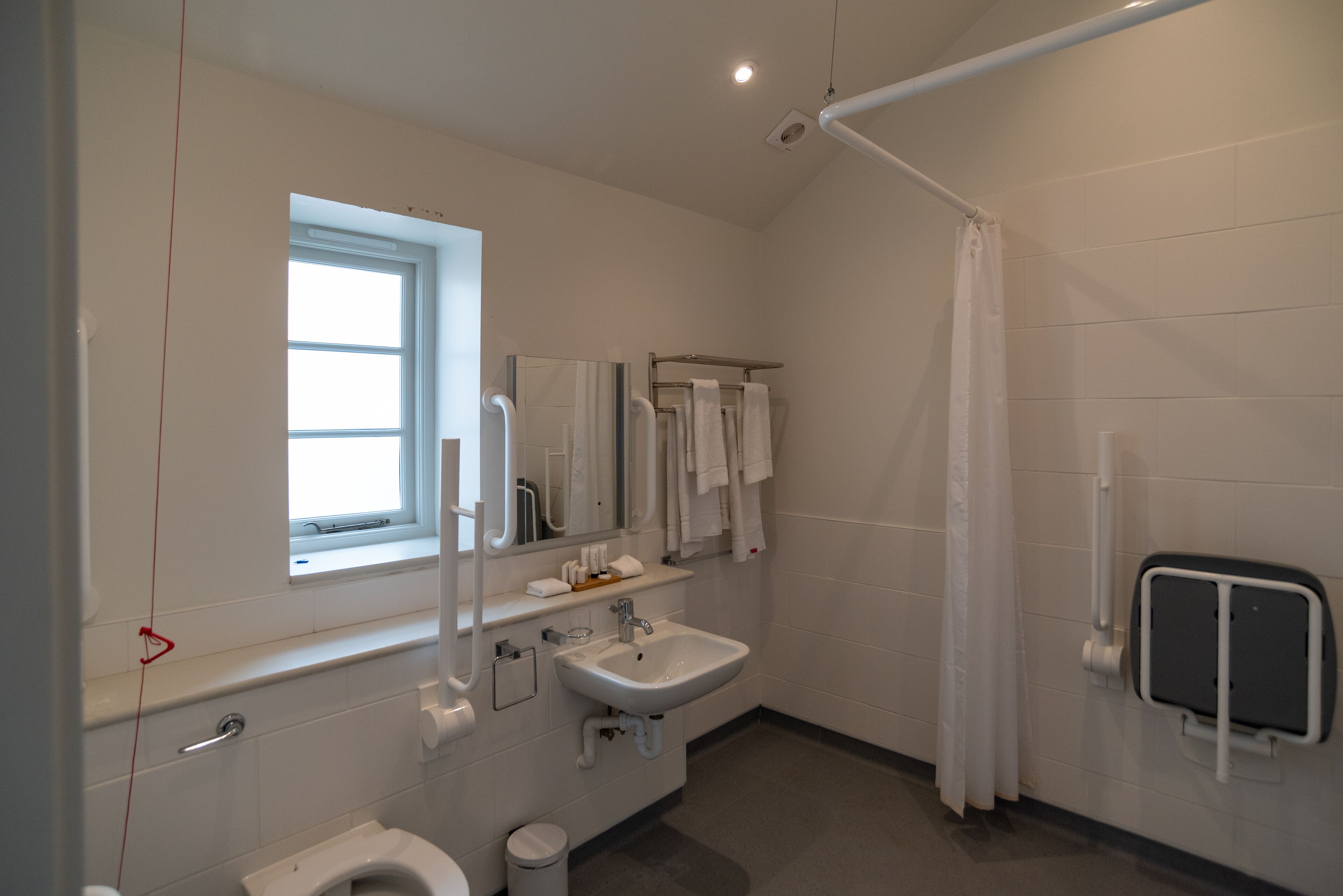 Une salle de bain moderne équipée de toilettes, d’un lavabo et d’une douche.