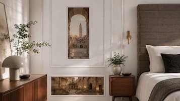 A bedroom with a bed, bedside tables, a lamp, and framed pictures on the wall.
