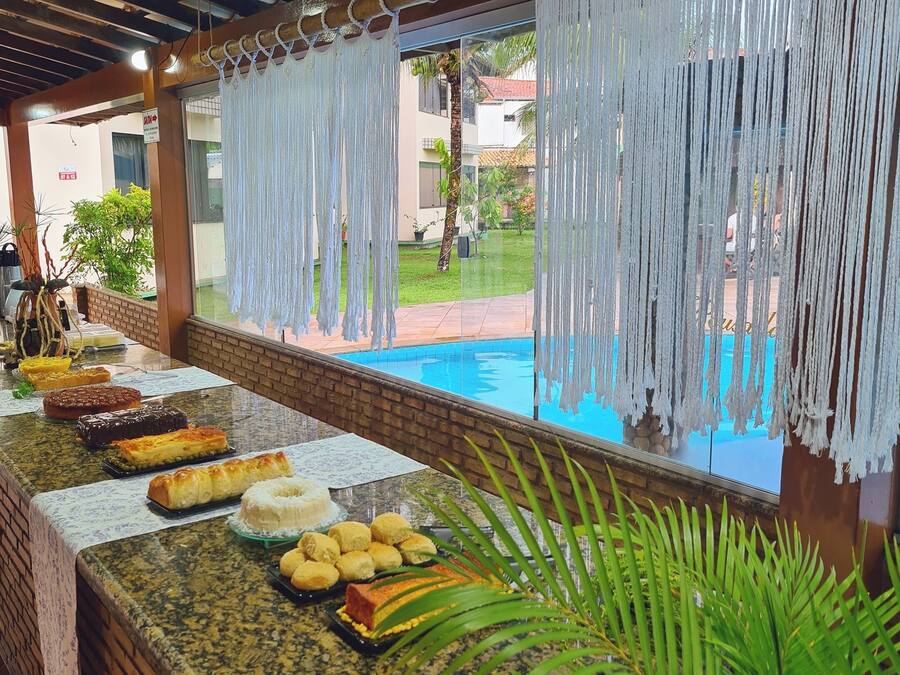 A buffet table with various dishes, a pool in the background, and a view of a residential area.