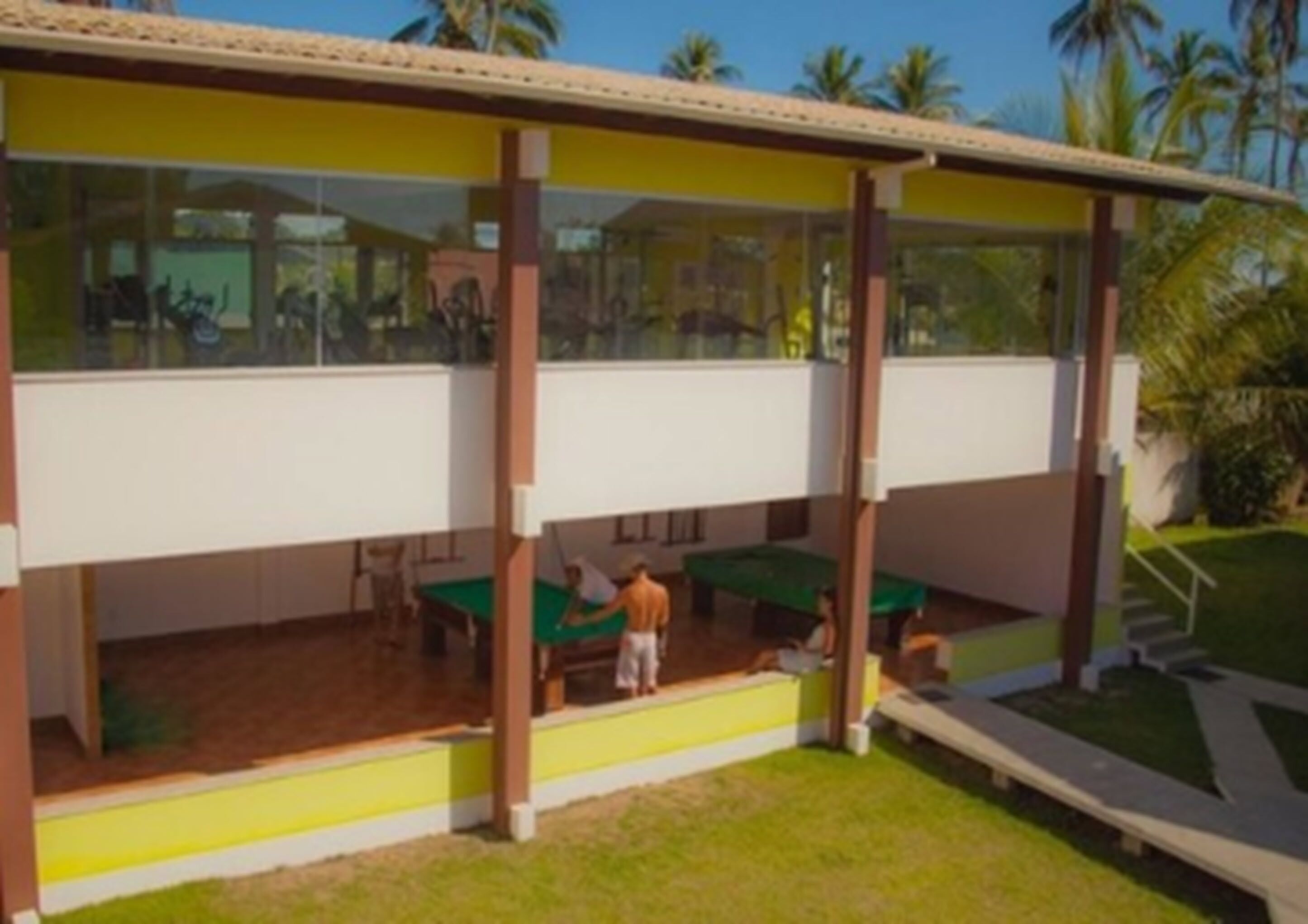 A building with a covered outdoor area featuring a pool table and a billiards table.