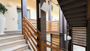 A staircase with wooden railings leading to an upper level. - Demetra Guest House (Rome)
