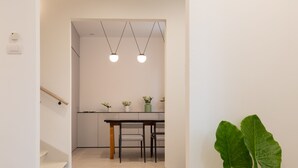 Una cocina moderna con una mesa y sillas, una escalera y una planta verde grande.