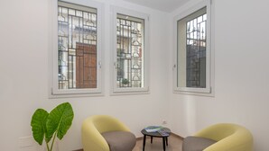 Una habitación con dos sillones amarillos, una mesita y una planta verde grande.