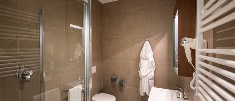 Une salle de bain moderne avec une douche à parois de verre, des toilettes, un lavabo et un porte-serviettes.