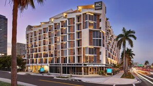 A multi-story hotel with a modern design, featuring a prominent 'AC' sign on the top.