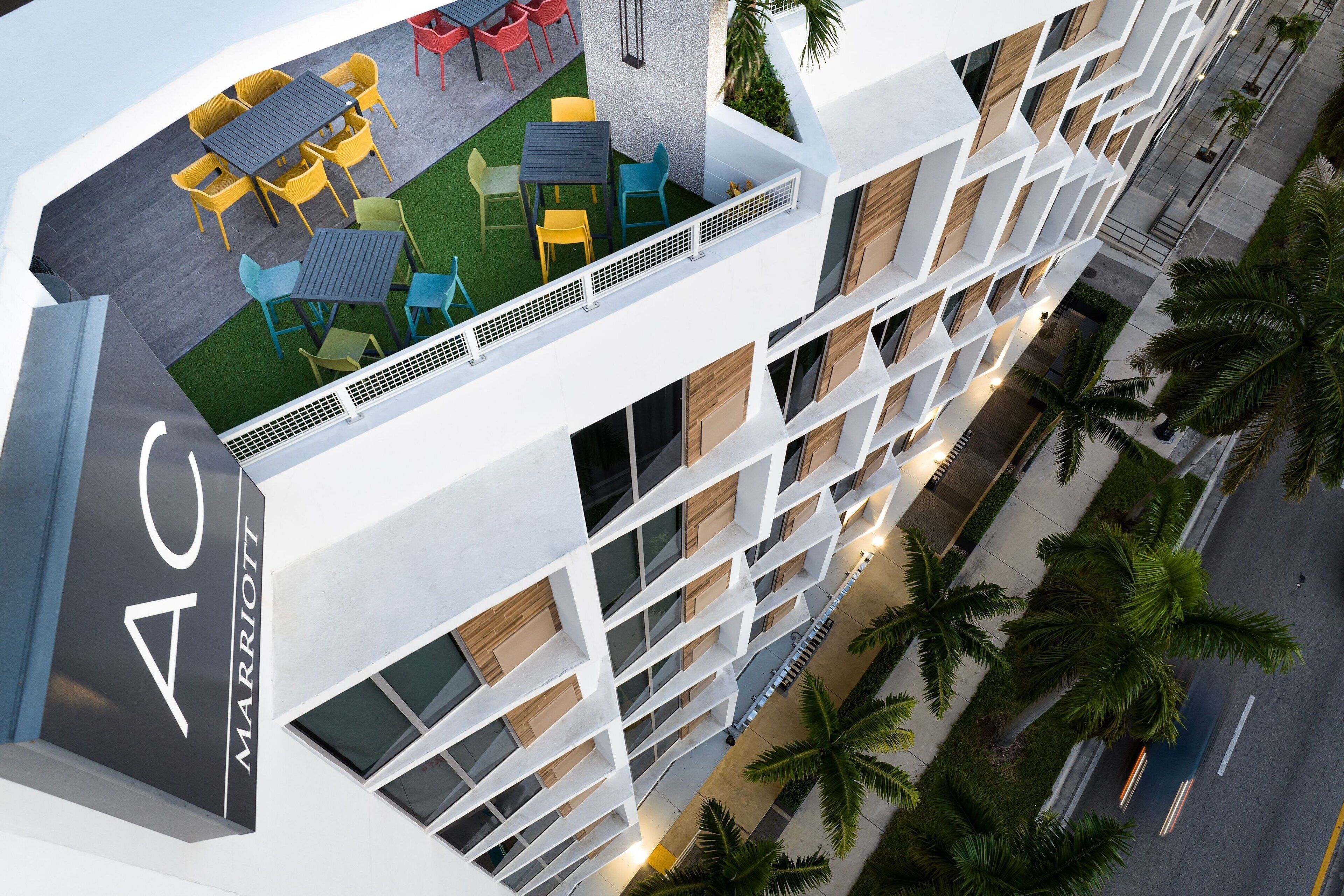 Un hôtel moderne doté d’un patio sur le toit, d’un espace extérieur aménagé et offrant une vue sur la rue.