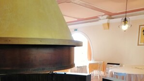 Chimenea de piedra circular con chimenea, rodeada por un área de asientos con un banco curvo.