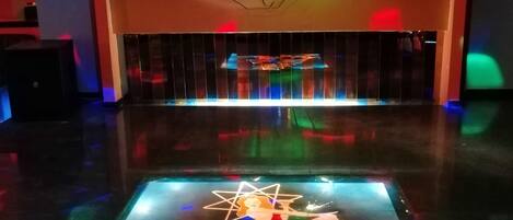 A dance floor with a neon sign reading "Bello Bello" and a star above it.