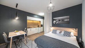 A modern hotel room with a bed, bedside table, and a view of a cityscape. - Amarant Apart Hotel (Kyiv)