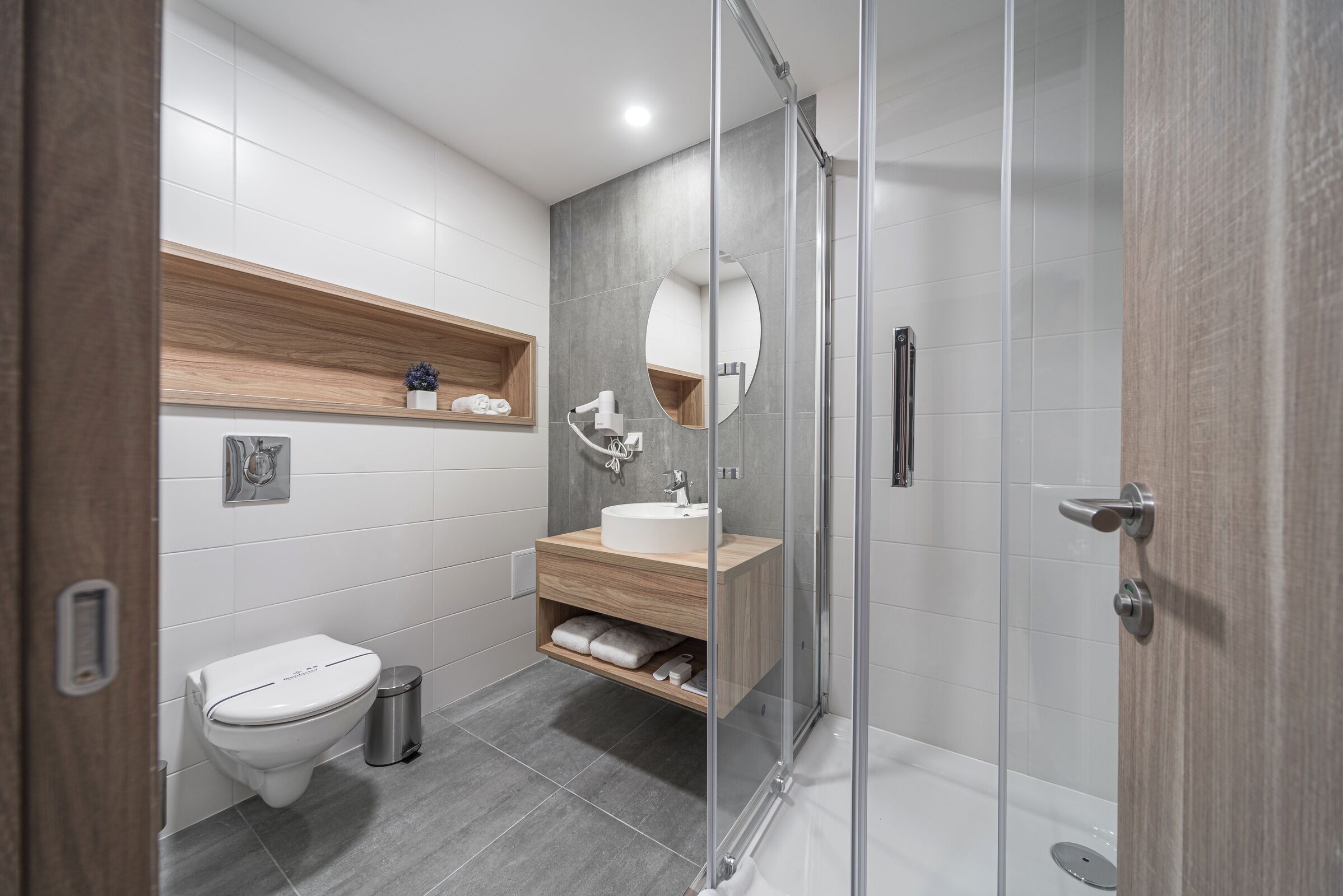 Ein modernes Badezimmer mit Toilette, Waschbecken und Dusche.