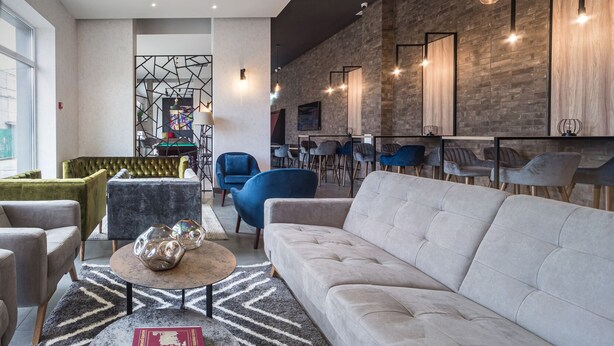 A modern living room with a sofa, chairs, a coffee table, and a fireplace. - Amarant Urban Hotel (Kyiv)
