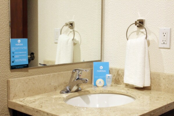 A bathroom sink with a mirror, a towel hanging on a ring, and a sign for 'noktos' soap. - NOKTOS Extended Ciudad del Carmen (Ciudad del Carmen)