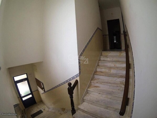 A staircase with marble steps and a handrail, leading to a door at the top. - Come Inn Sesimbra (Sesimbra)