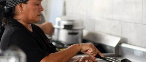 Una persona cocinando en una cocina con estufa y ollas.
