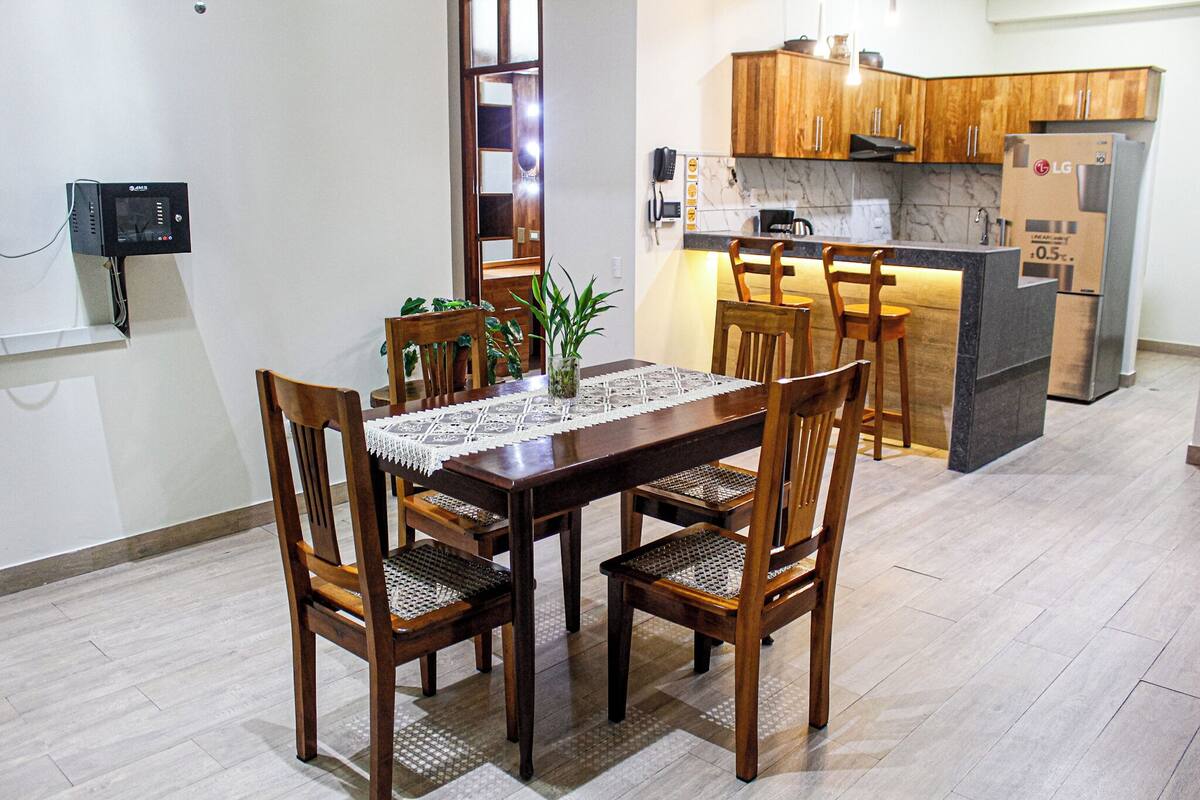A modern kitchen with wooden cabinets, a built-in island, and a refrigerator.