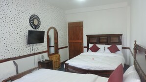A hotel room with two beds, a wooden headboard, a wall-mounted TV, a mirror, and a wooden wardrobe. - White Tower Villa  Sri Lanaka (Nuwara Eliya)