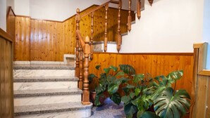 Una escalera de madera con escalones de mármol y barandilla de madera.