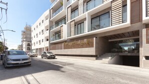 A modern multi-story building with a flat facade, large windows, and a covered entrance. - Icono 405 (Playa del Carmen)