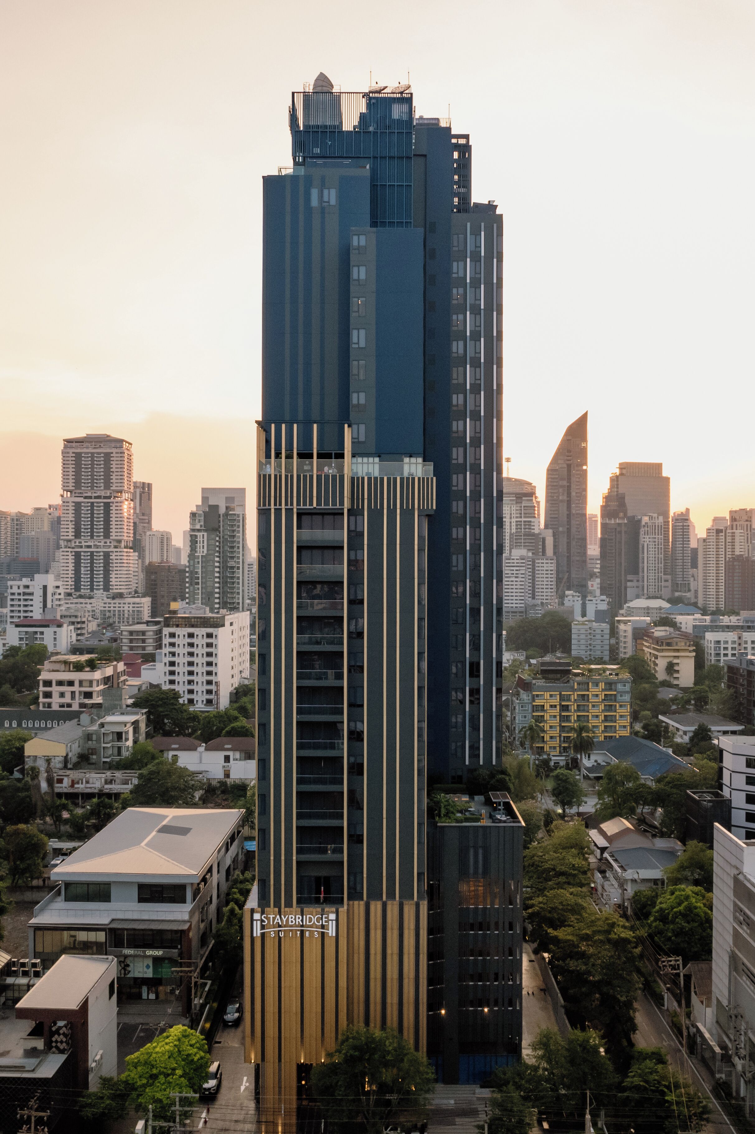 Een hoog gebouw met een modern ontwerp, gekenmerkt door verticale lijnen en een opvallende entree.