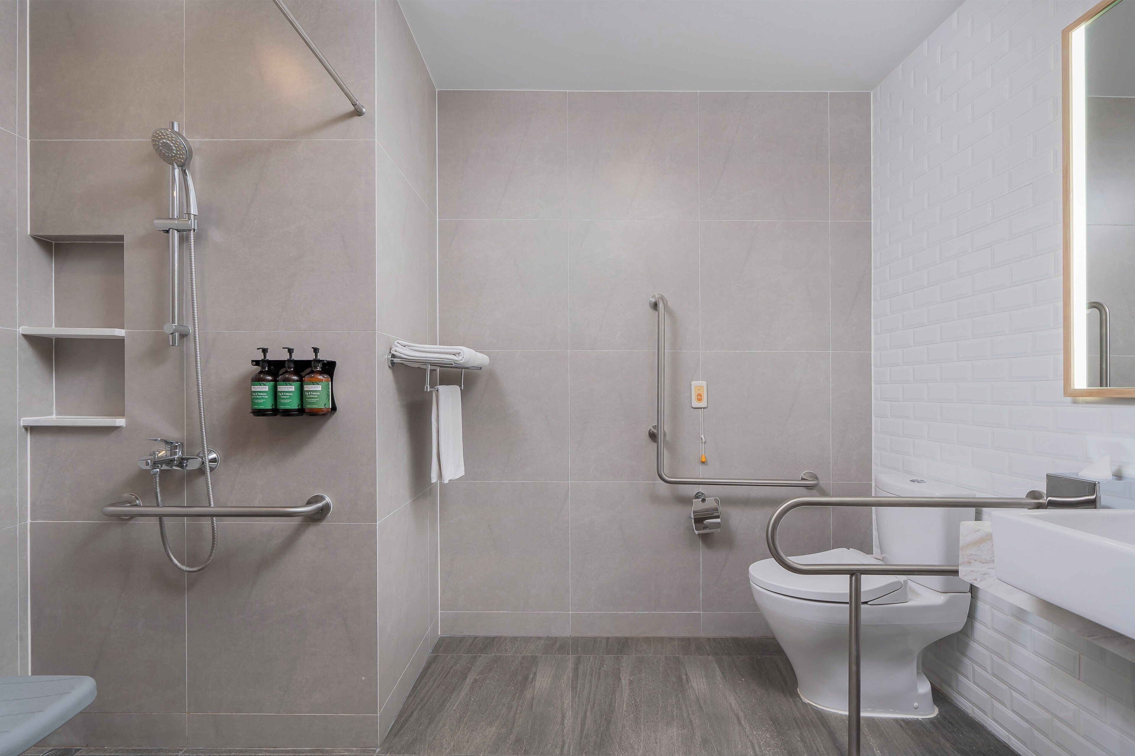 A modern bathroom with a shower, toilet, and sink.
