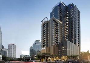 Un hôtel de grande hauteur, avec de nombreux étages, de grandes fenêtres et une enseigne bien visible.