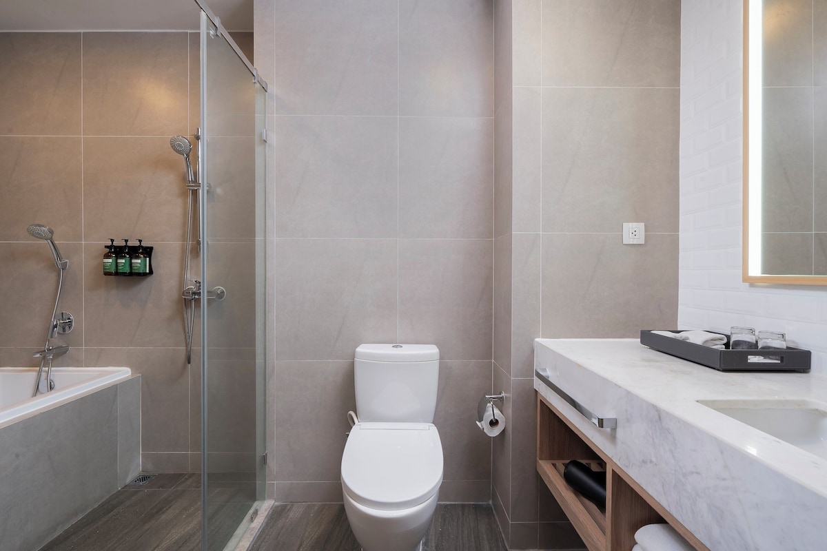 Une salle de bain moderne équipée d’une douche, de toilettes et d’un lavabo.