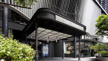 A modern building with a curved entrance and a sign reading "Eight Thonglor".
