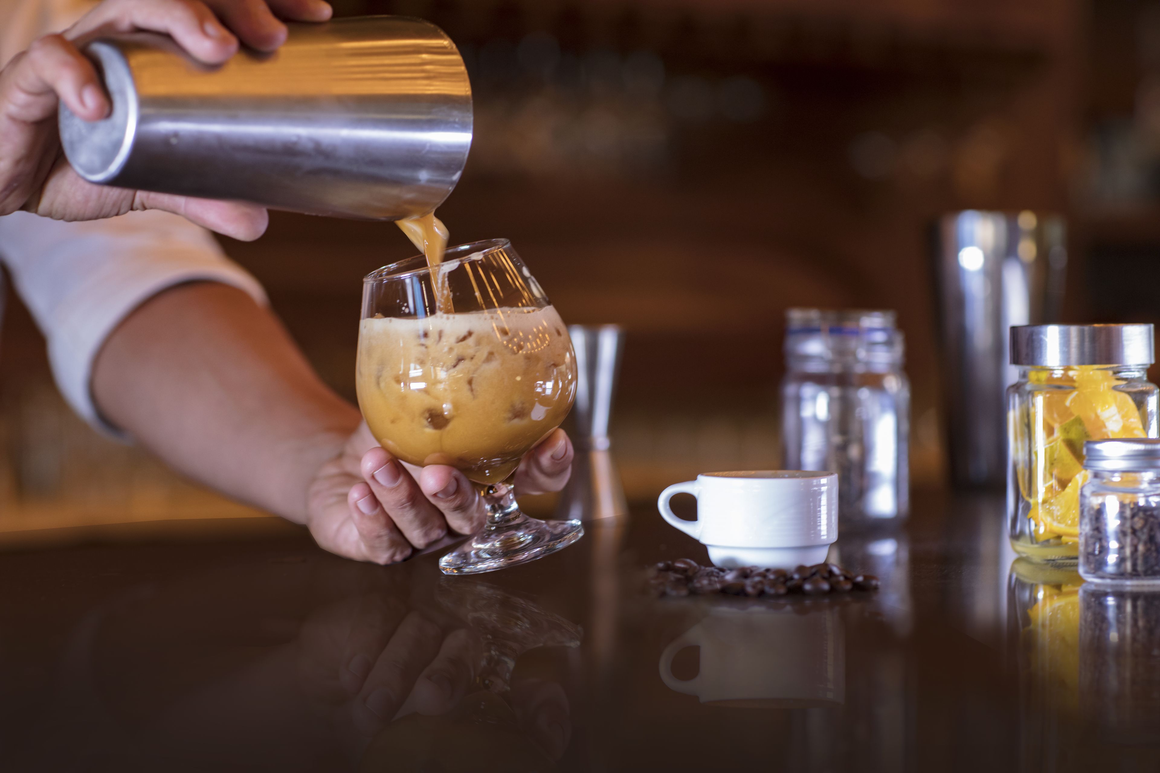 A person pouring a drink into a glass.