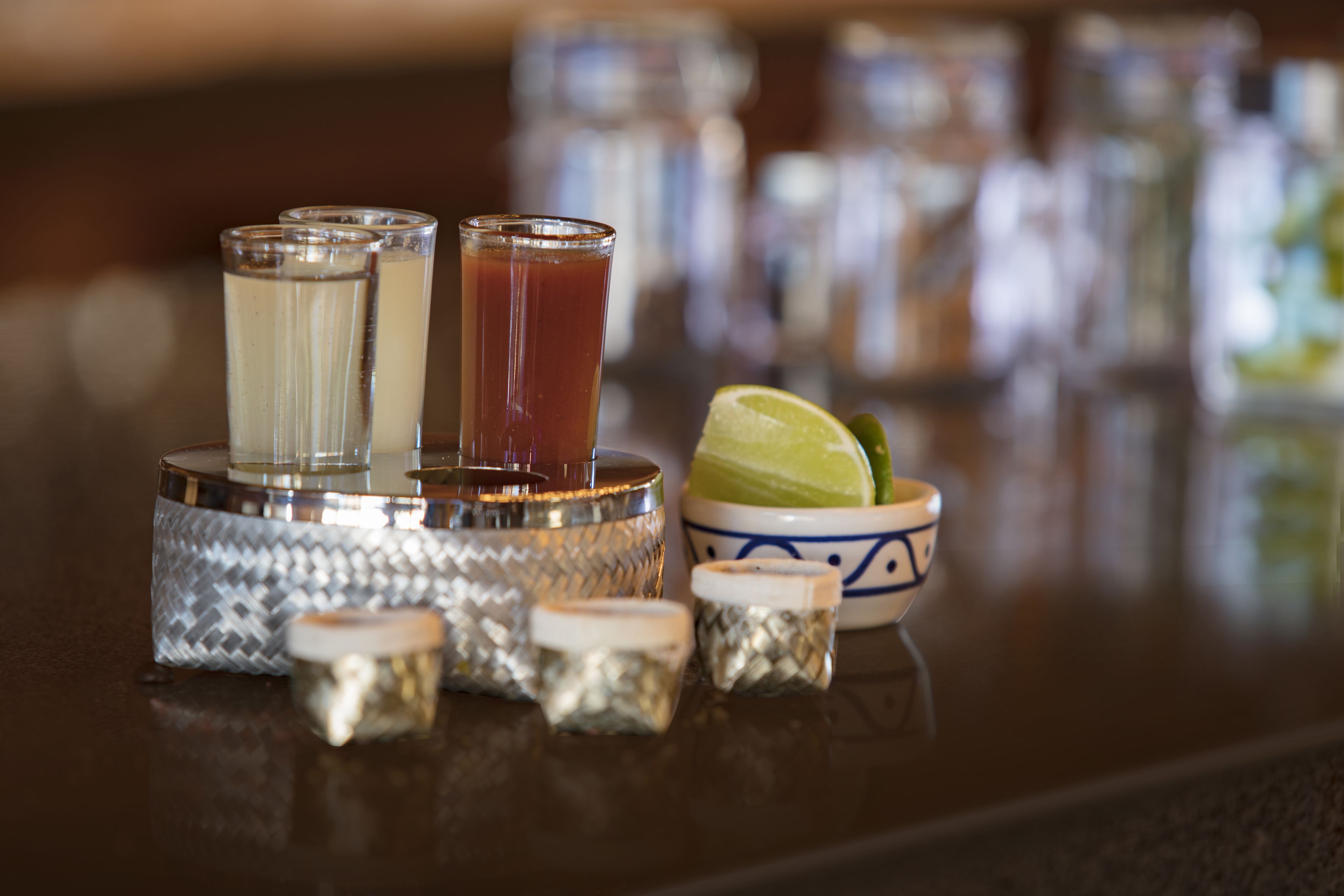 Un bar con diferentes vasos y aderezos.