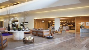 A spacious lobby with a marble coffee table, seating area, and a reception desk. - Hyatt Centric Campestre Leon (León)