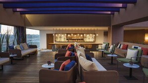 A modern outdoor lounge area with seating and a bar. - Hyatt Centric Campestre Leon (León)
