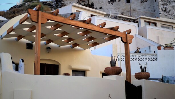 Un edificio con una pérgola, una bandera y un mural de un barco.