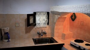 Una cocina con un lavaplatos, una cafetera y una estufa.