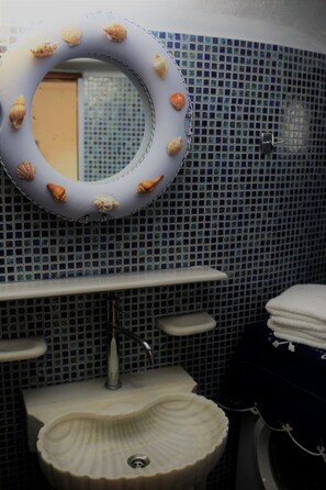 Ein Badezimmer mit Waschbecken, Spiegel und gefliesten Wänden.