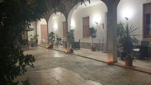 Zona exterior coberta amb terra de rajola, plantes en testos i zones d'ambientació.