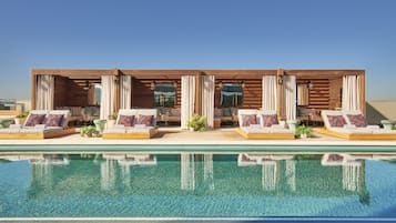 Una piscina al aire libre, sillones reclinables de piscina