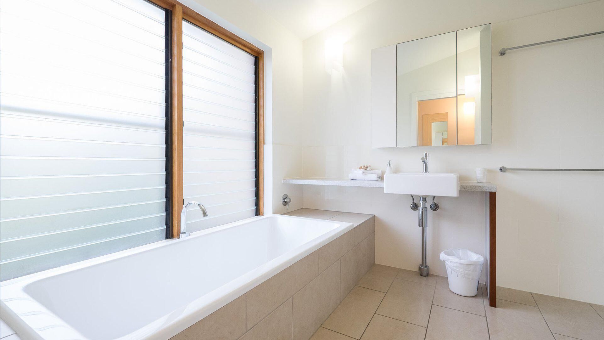 Ein modernes Badezimmer mit Badewanne, Waschbecken und Spiegel.