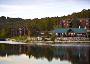 A lakeside lodge with multiple buildings, a dock, and a stone retaining wall.