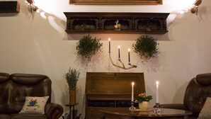 A cozy living room with a fireplace, leather sofas, a wooden coffee table, and a large mountain painting above the mantel. - - Take a break and reconnect at Farmhouse Kamovci21 - (Kamovci)