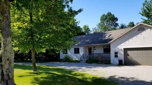 A single-story house with a front porch, a garage, and a driveway. - Heated pool-fire pit-central air-near PRNL (Christmas)