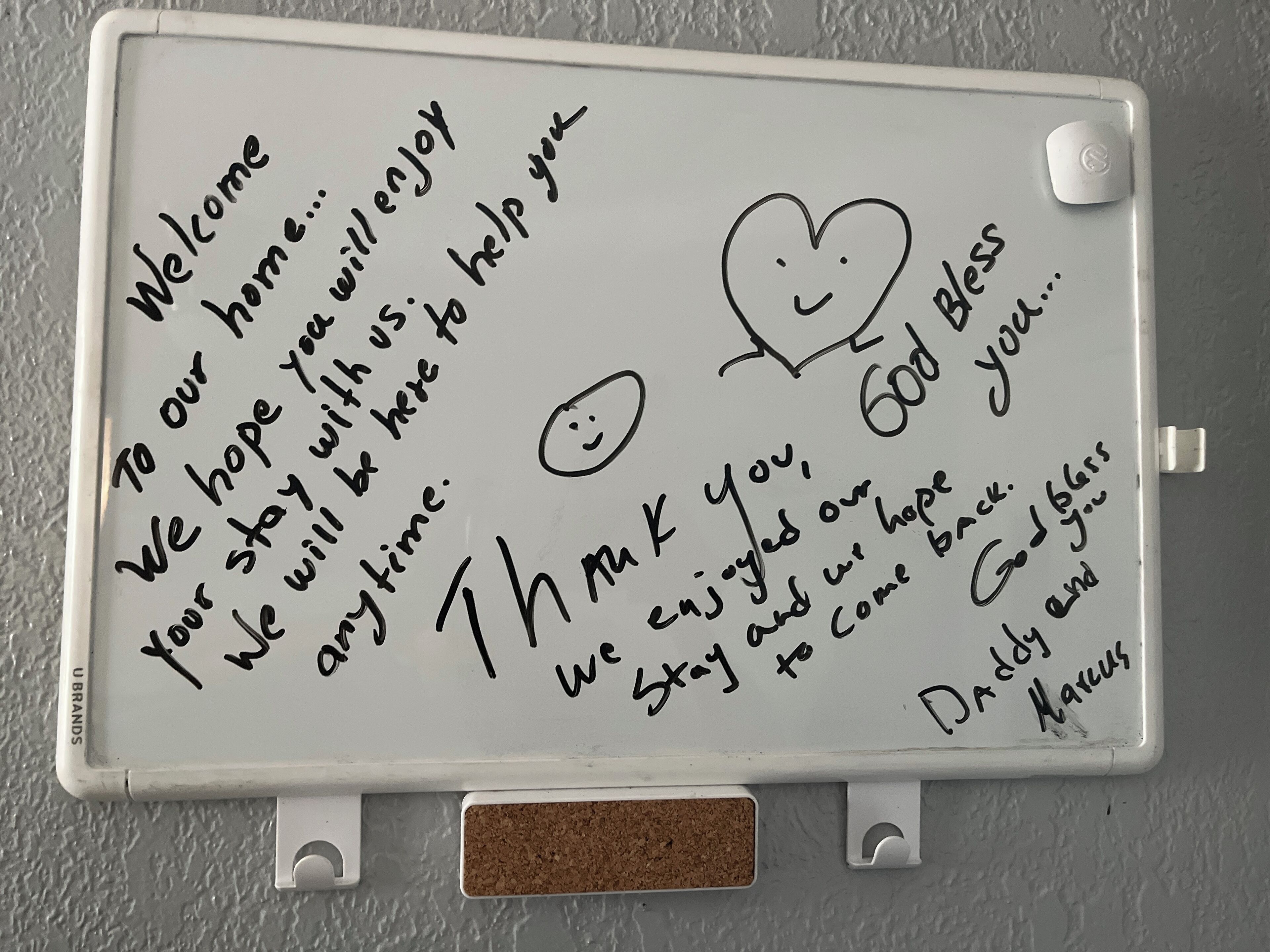A whiteboard with handwritten messages and a smiley face.