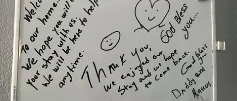 A whiteboard with handwritten messages and a smiley face.