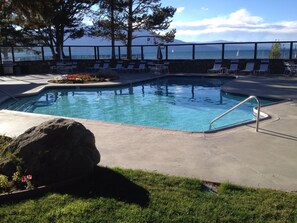 Ein Swimmingpool mit Liegestühlen und Blick auf das Meer.