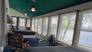 A room with a large bed, a smaller bed, a chair, and a desk. There are windows with blinds, a ceiling fan, and a lamp. - Amazing sunsets/lake views - Near Pictured Rocks (Christmas)