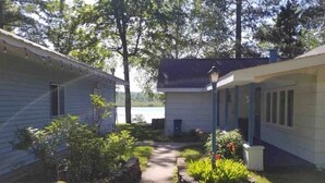 A small, two-story house with a covered porch and a pathway leading to the entrance. - Amazing sunsets/lake views - Near Pictured Rocks (Christmas)