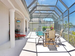 Ein sonnendurchfluteter Innenhof mit Glasdach, Pool und Blick ins Freie.