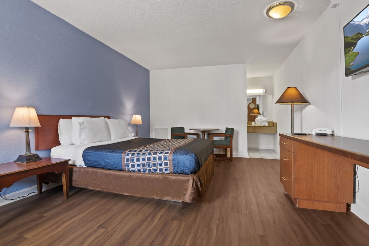 Une chambre d’hôtel comprenant un lit, des tables de chevet, un bureau et une chaise.