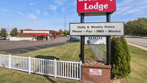 A sign for Economy Lodge with daily and weekly rates for phone, fax, HBO, and movies. - Economy Lodge (Portsmouth)