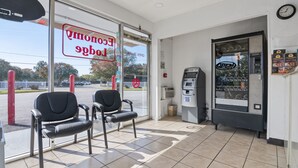 A drive-thru window with two chairs, an ATM, and a food vending machine. - Economy Lodge (Portsmouth)