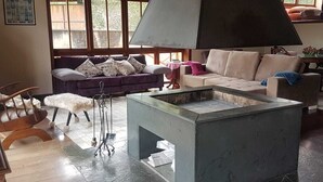 Una sala de estar con chimenea, dos sofás y una mesita de centro.